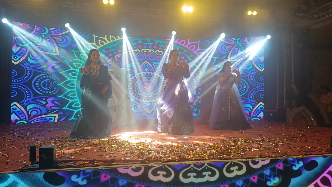 Sangeet performance on a stage wrapped in LED mandala screens