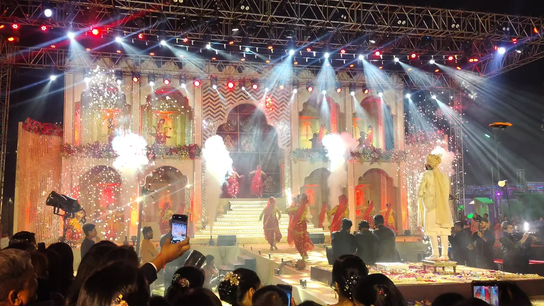 Palace-facade stage built on an open lawn and lit for an evening wedding